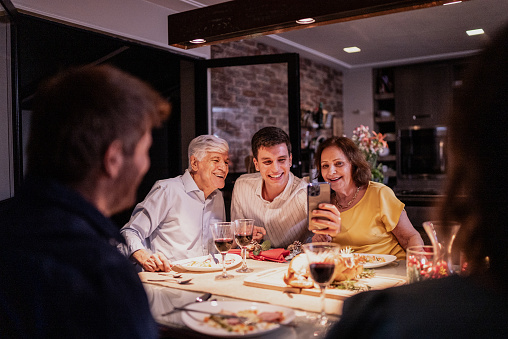 Grandchild taking a self with grandparents at Christmas dinner