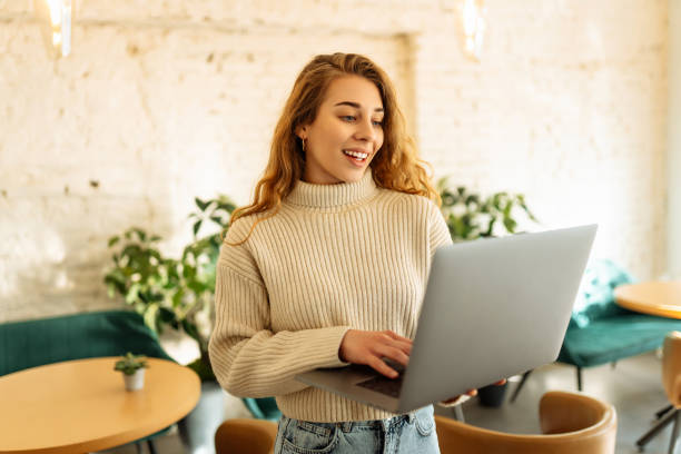 istock Young woman works with a laptop while sitting in a cafe. 1823036469