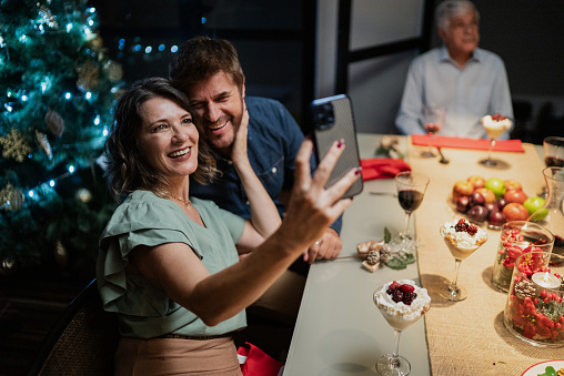 Mature couple taking a selfie at Christmas dinner