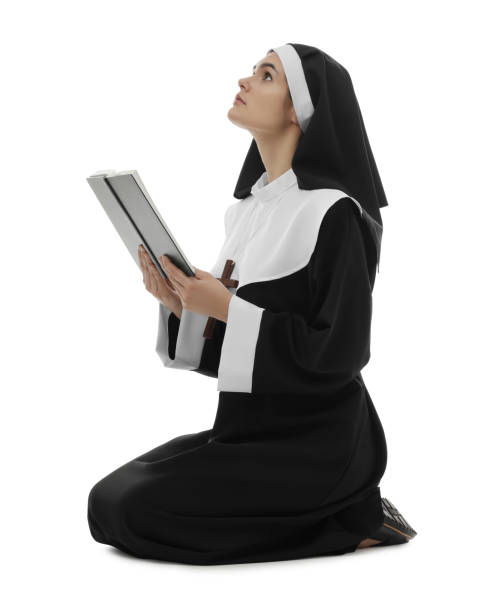istock Young nun with Bible praying to God on white background 1823059382