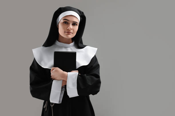 회색 배경에 성경�을 들고 있는 수녀, 텍스트를 위한 공간 - nun habit catholicism women 뉴스 사진 이미지