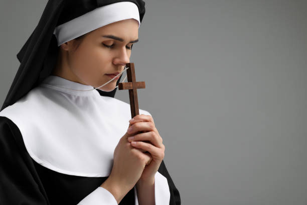 istock Nun with cross praying to God on grey background. Space for text 1823062287
