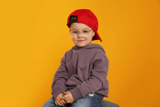 istock Cute little boy in glasses on orange background 1823066321