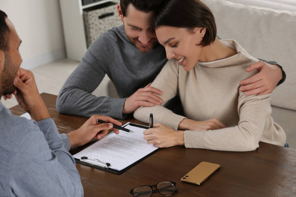 istock Professional notary helping couple with paperwork at wooden table 1823078967