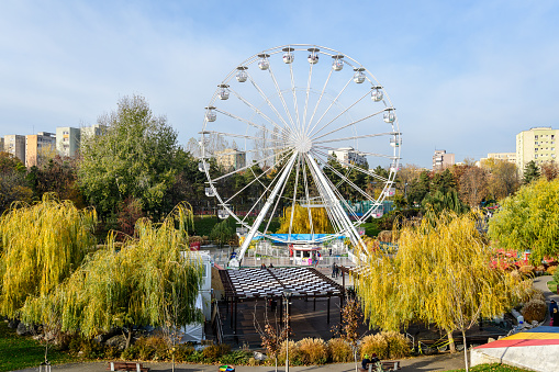 Bucharest, Romania, 30 November 2023: Big wheel at the West Side Christmas Market in Drumul Taberei neignbourhood, in a sunny cold day with blue sky