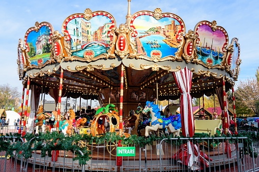 Bucharest, Romania, 30 November 2023: Vivid colorful carousel at the West Side Christmas Market in Drumul Taberei neignbourhood, in a sunny cold day with blue sky
