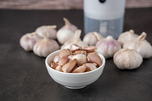 Big and small heads of garlic on a black background.