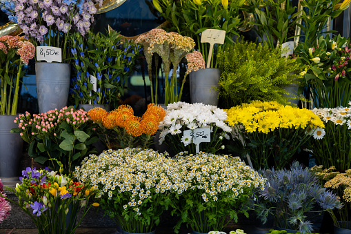Selective focus color image depicting beautiful fresh spring flowers for sale outside a florist shop. Focus is on the flowers and vases in the foreground, while the background is nicely blurred out of focus. Room for copy space.