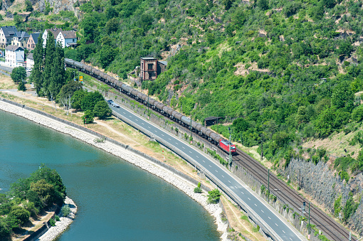 View from the Loreley viewpoint at the river Rhine with a freight train travelling on the East bank. The viewpoint on top of the Loreley rock is at an altitude of 125 meters over the Rhine.