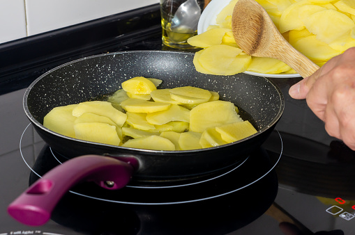 Traditional Spanish Cuisine: Cook Adding Potatoes to the Pan to Prepare a Tortilla.
