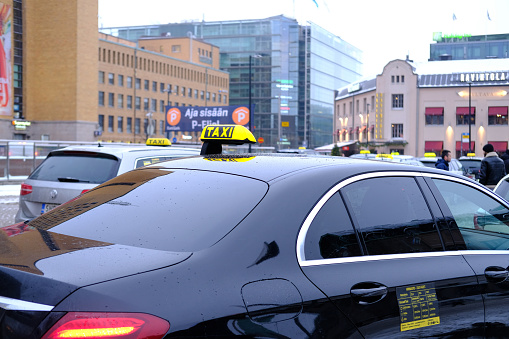 Finnish car with sign Taxi waits for passengers on street of Helsinki city, public transport concept used to transport passengers to point with payment taximeter, Helsinki, Finland - January 1, 2022