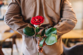 Close-up of a woman holding a rose to do a surprise