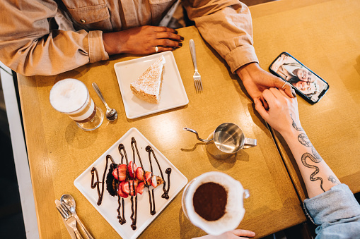 High angle view of a lesbian couple on a table with dessert and coffee