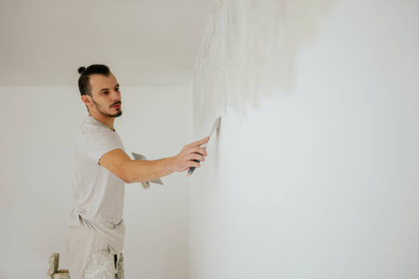 istock A builder on ladder is using spatula and trowel for plastering walls. 1823240234