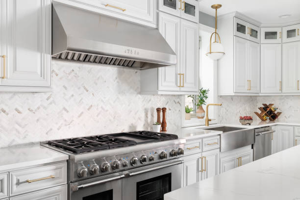 istock A kitchen detail with grey cabinets, gold accents, and a herringbone tile backsplash. 1823291250
