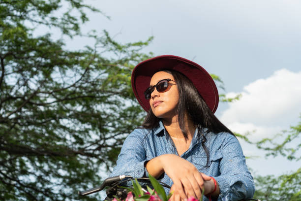 Latin woman riding a bicycle in nature.
