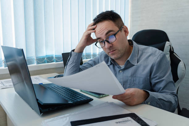 istock An employee is surprised to read a paper document while sitting at the workplace. Businessman being depressed by accounting in his office 1823391943