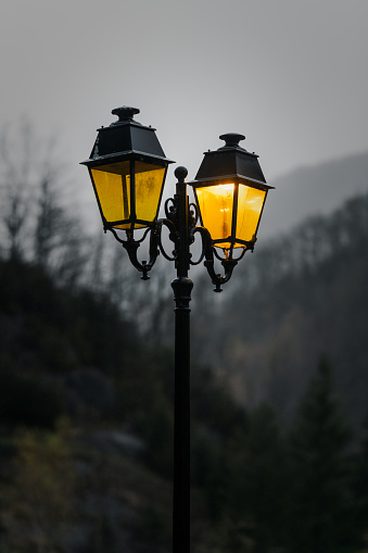 Orange light of a street lanterns in the mountain village at dawn. soft focus, shallow depth of field