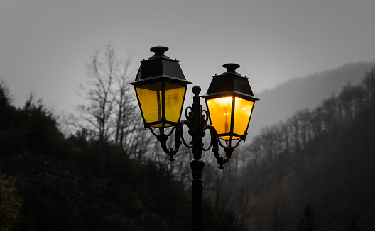 Orange light of a street lanterns in the mountain village at dawn. soft focus, shallow depth of field