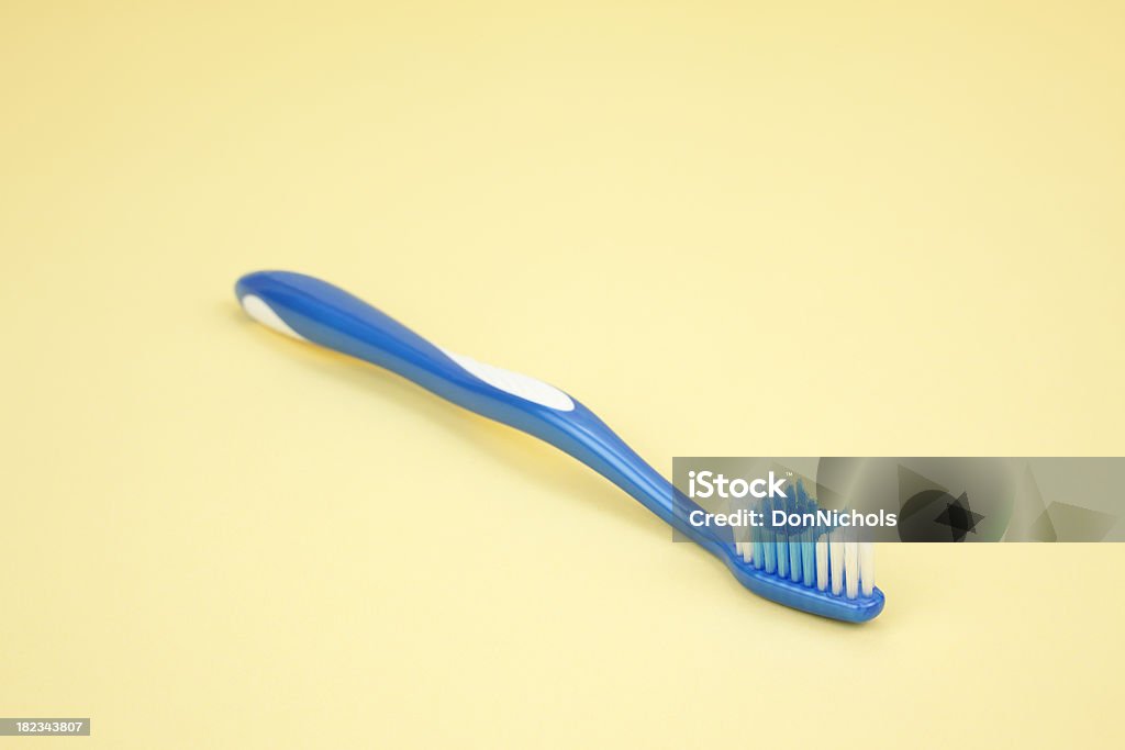 Spazzolino blu su giallo - Foto stock royalty-free di Apparecchiatura odontoiatrica