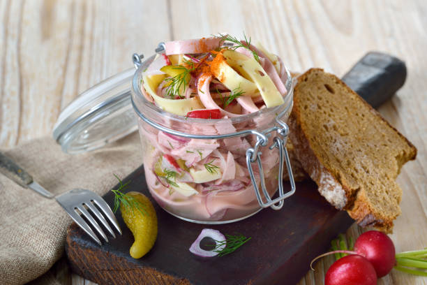 A typical German wurst salad a delicious light meal of meat, pickles, bell peppers, and vinaigrette dressing. Horizontal shot.