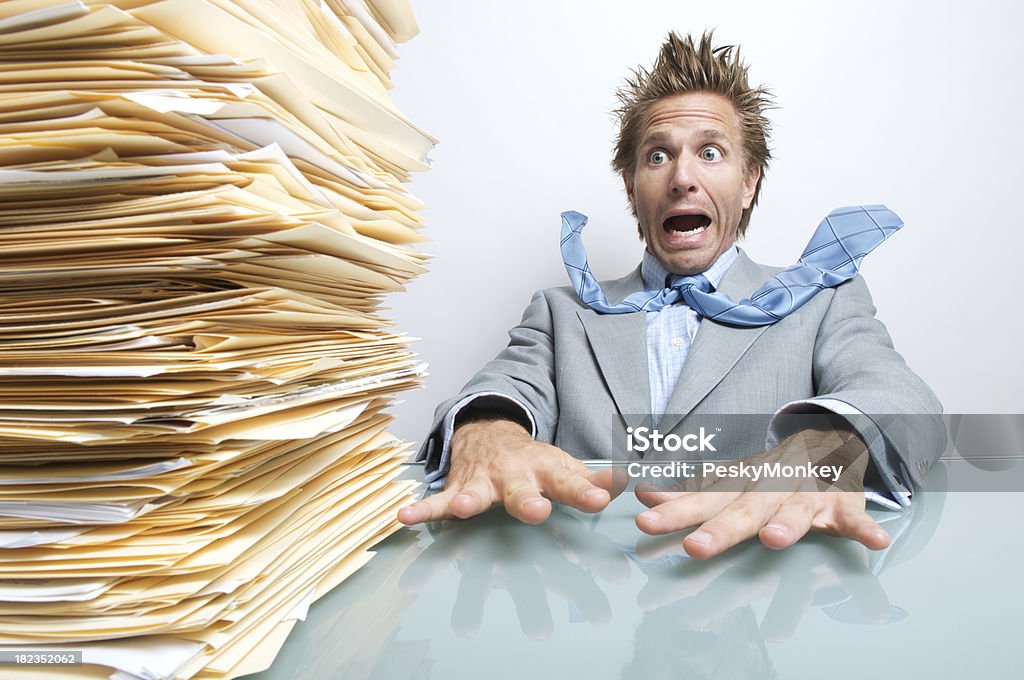 STRESSATO Uomo d'affari ufficio lavoratore Ansimare all'enorme pila di documenti - Foto stock royalty-free di Lavoro d'ufficio