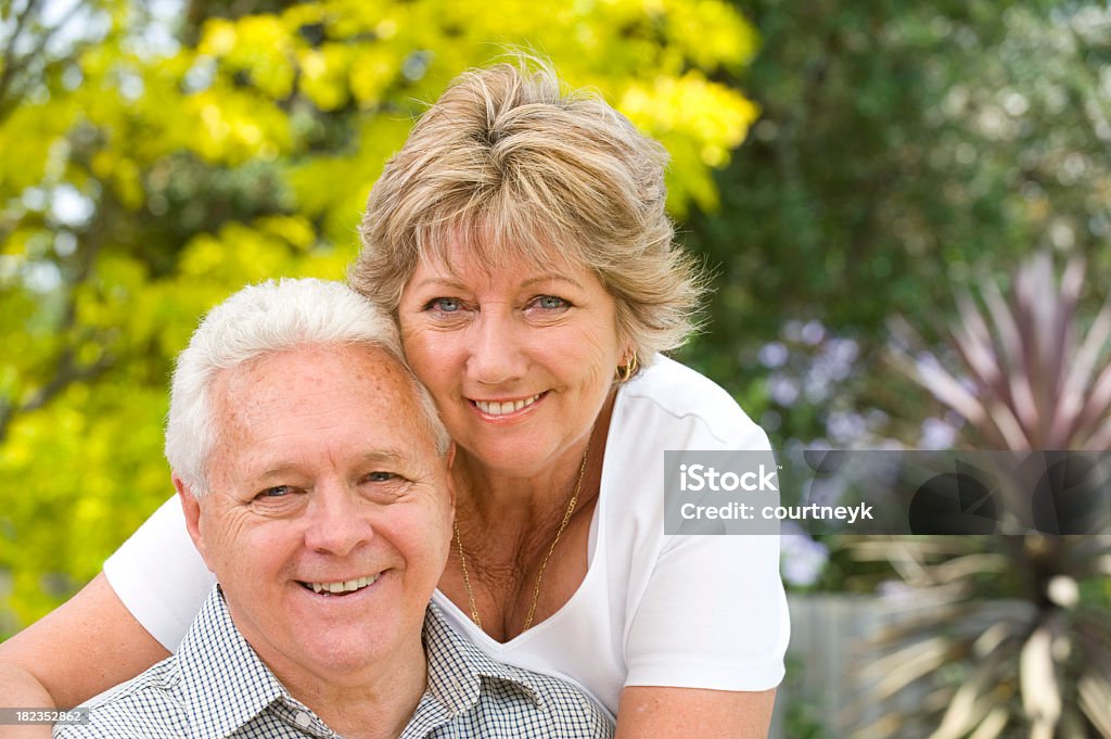 couple Senior souriant avec flou fond le jardin - Photo de Adulte libre de droits