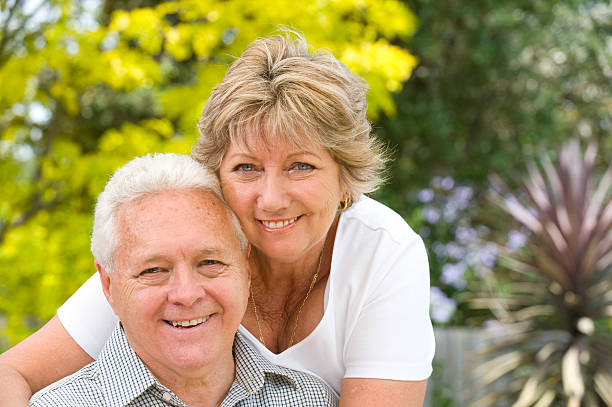 istock Senior couple smiling with blurred garden background 182352862