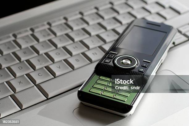 Foto de Telefone Celular Em Um Laptop e mais fotos de stock de Cinza - Descrição de Cor - Cinza - Descrição de Cor, Computador, Comunicação