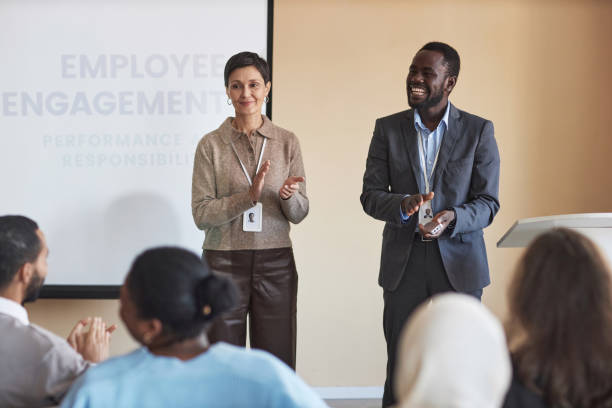 istock Successful mature coach and her assistant clapping hands in front of audience 1823543514