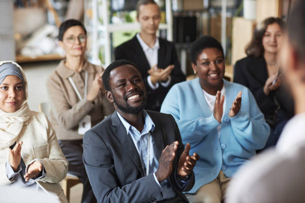istock Group of young intercultural people sitting in row and clapping hands 1823544047