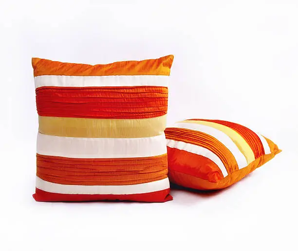 Photo of Red orange and white throw pillows on a white background