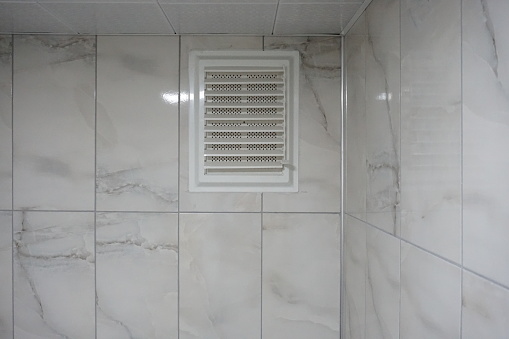 Toilet ventilation. air vent in the wall. Plastic air vent. Ventilation on marble wall.