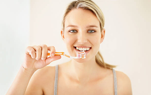 istock Pretty young girl brushing her teeth 182355059