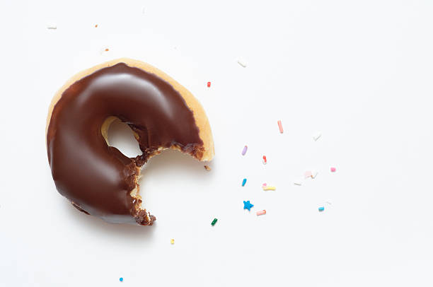 Half eaten chocolate doughnut with sprinkles stock photo