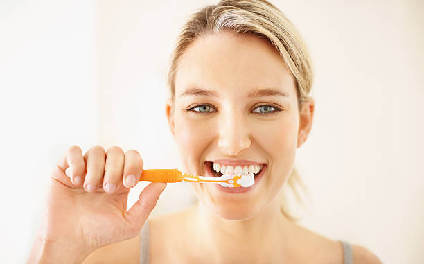istock Pretty young girl brushing her teeth 182357116