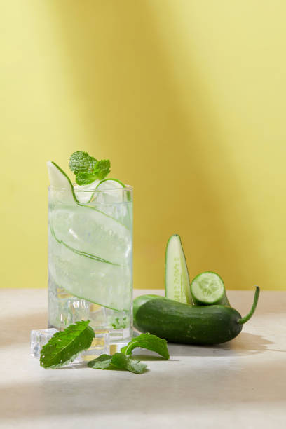 Make your own detox water on a hot summer day with fresh cucumbers and ice. Front view of minimalist background. Copy image for newspapers and magazines.
