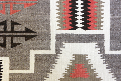Authentic historic Navajo woven wool blanket design showing age and use stains.  The Navajo stained their yarns for fabrics using natural items from the surroundings - beige from corn silk, tan from brown onion skin, maroon from Juniper bark, amber from Juniper Mistletoe, olive-yellow from sagebrush, gray from Indian Paintbrush, brown from the Gambel Oak, dark green from red onion skin, lavender from Holly berries, dusty orange from canaigre root - just a few of the earthtone colors produced for coloring yarns and other items.  Page, Arizona, 2010.