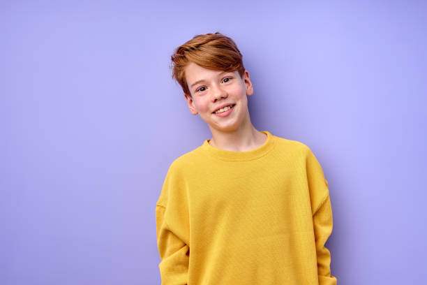 istock Young emotional handsome boy standing on purple studio background. 1823584074