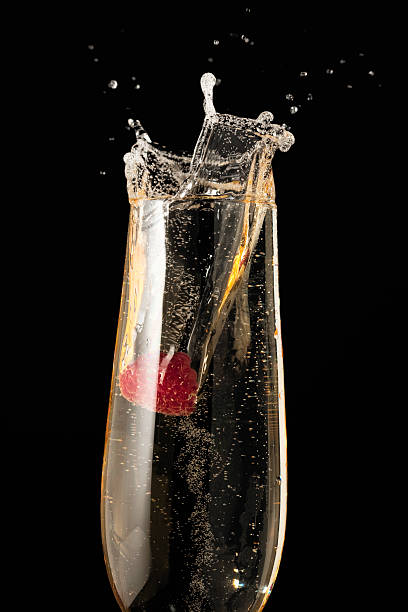 istock A red raspberry splashing into a flute of sparkling wine 182358746