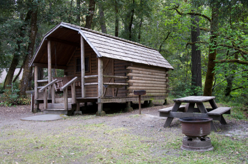 Rustic camping cabin and picnic table in campground