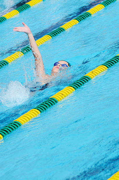 istock Young Boy Male Athlete Backstroke Swimming Racing in Pool 182359101