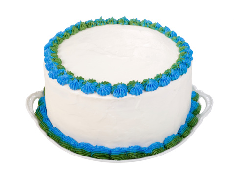 Homemade birthday or party cake frosted with white icing and decorated with blue and green details. The top of the cake is plain white so you can personalize it.