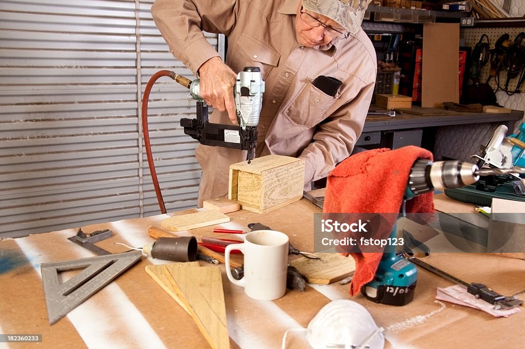 Caja profesional trabajando con pistola de clavos verdadero banco de trabajo de taller - Foto de stock de Actividad libre de derechos