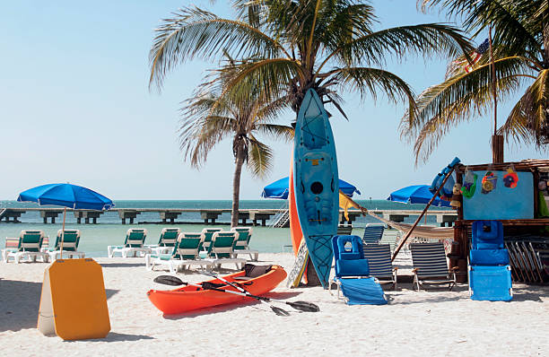 Canoe, kayak, chairs, toys for rent on beach. Copy space. stock photo
