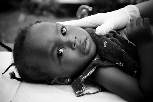 Little African girl crying while getting a checkup.