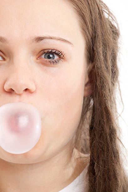 istock Young female blowing a chewing gum bubble 182361152