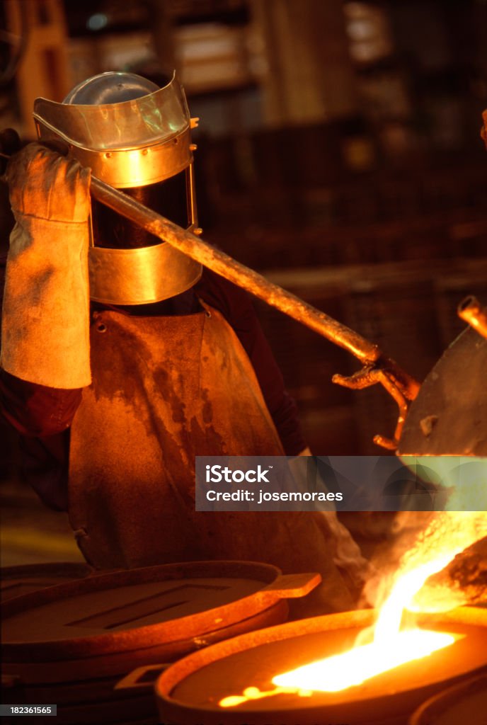Working in a Foundry "Man Working In a Foundry,Pouring Glowing Metal Alloy In A Mold." Foundry Stock Photo