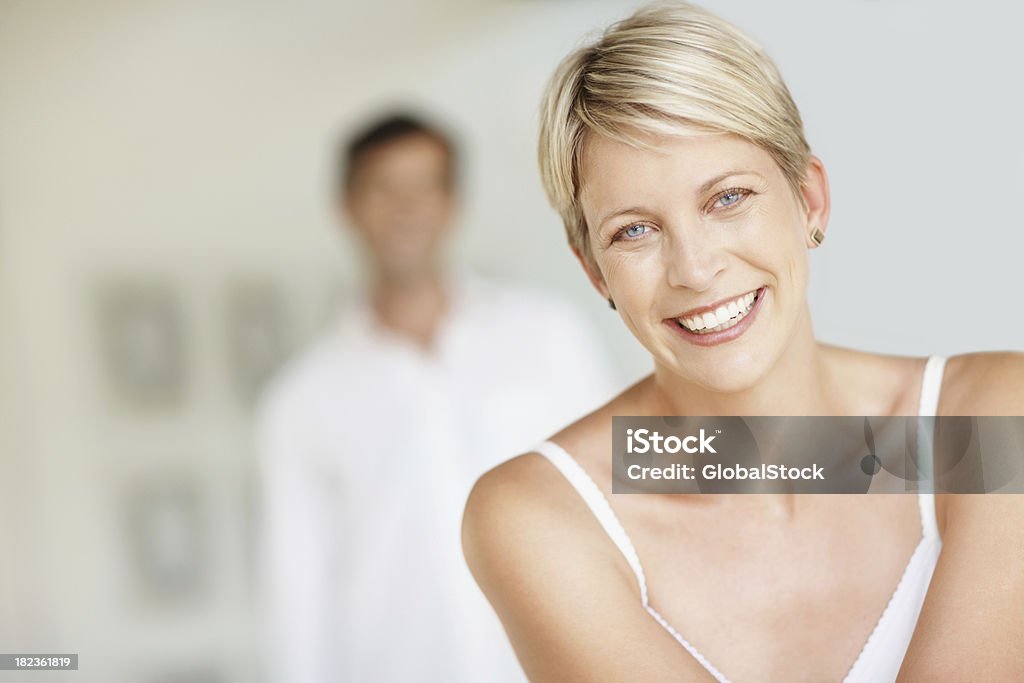 Meados idade mulher sorridente com o marido no fundo - Royalty-free 30-39 Anos Foto de stock