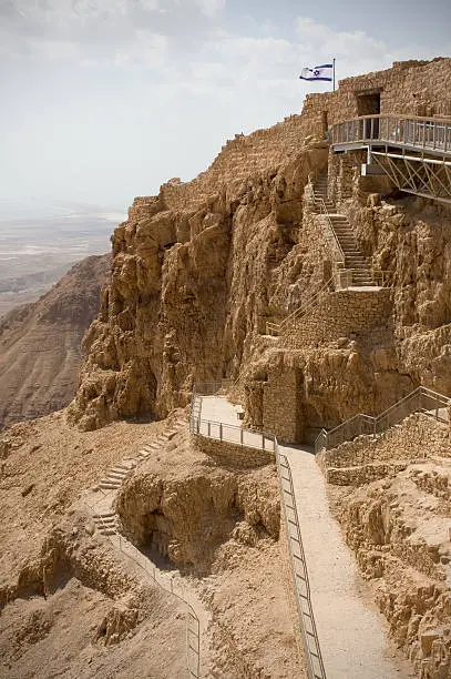The craggy edge of Masada, a historical location in Israel, reveals incredible views of the Judean Desert and Dead Sea. The climb from the bottom is a challenging one for the adventurous.